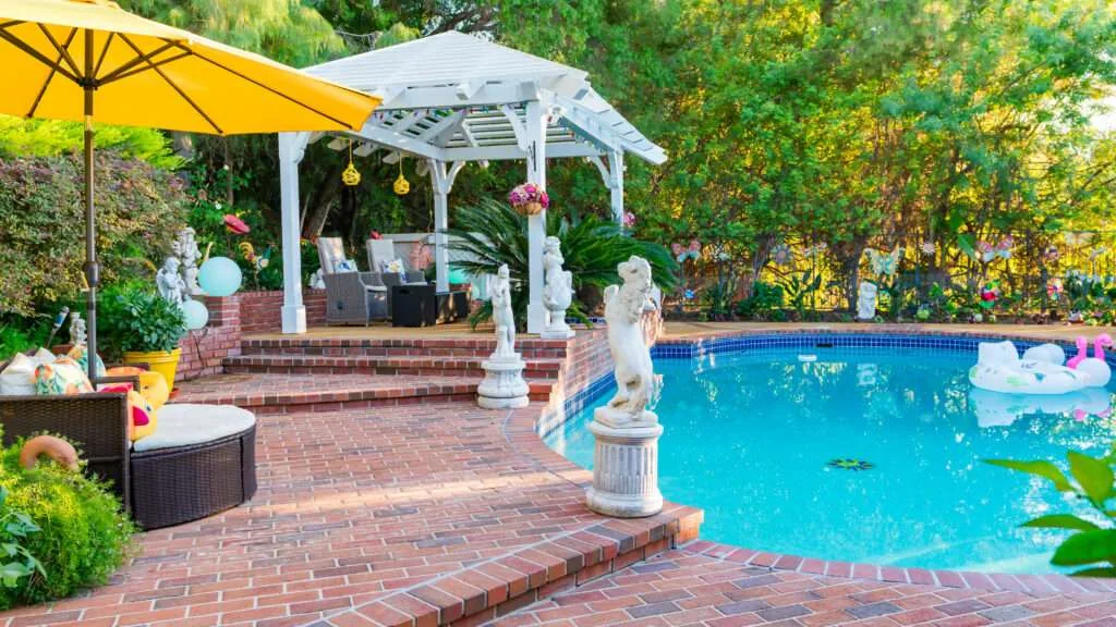 Hip roof pergola with surrounding planting and garden lighting near an existing pool in Encino, CA