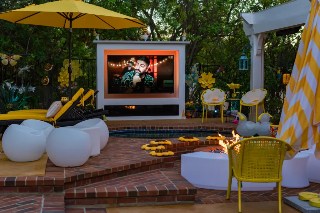 Custom stucco outdoor TV structure with decorative changing lighting, built-in natural gas fire pit, and outdoor entertainment area in Encino, CA