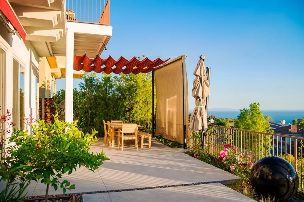 Modern hardscape patio with concrete pavers and retractable shade structure designed and installed by Lush Gardens Inc.