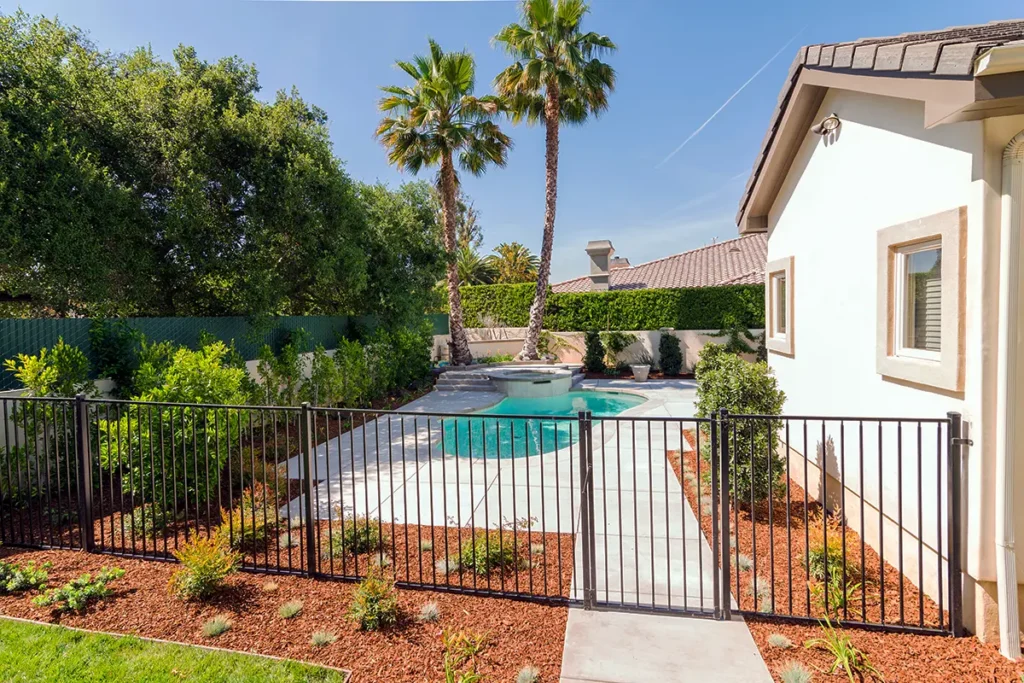 Custom horizontal wood gate and fence with stucco wall and modern exterior lighting