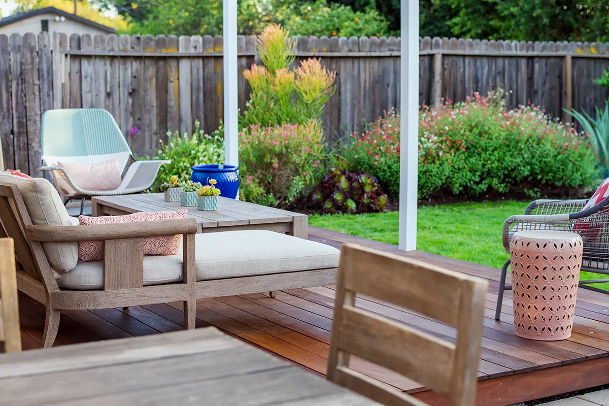 Landscape and softscape design with lawn, flowering planting beds, and wood deck patio