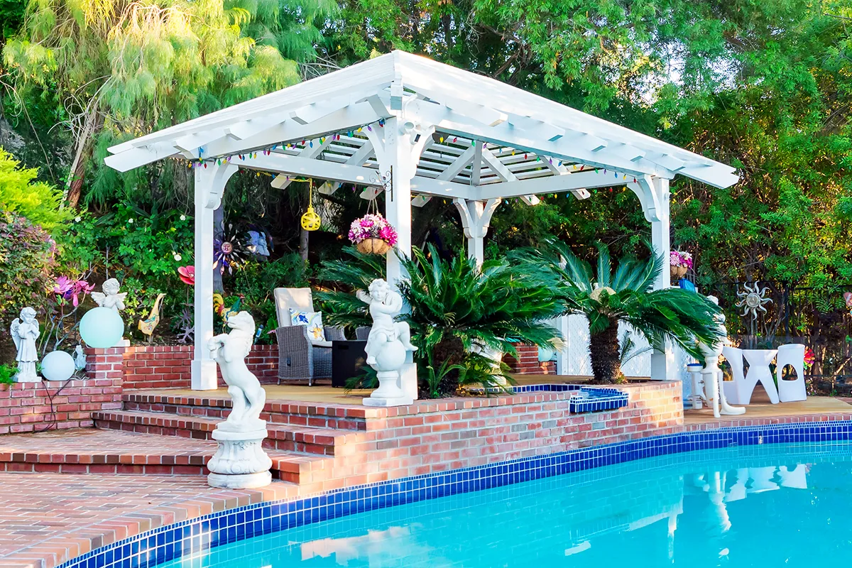 Custom pergola structure installed along a poolside patio area