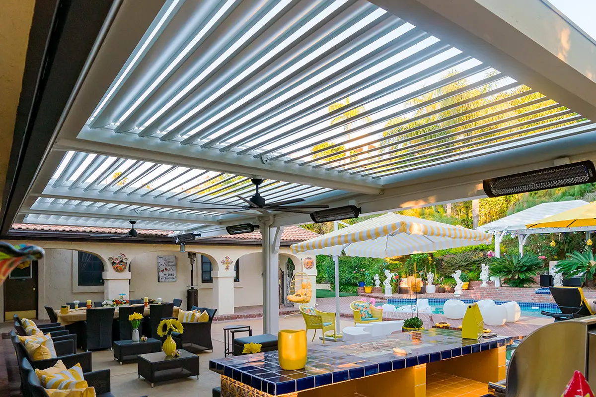 Custom louvered patio cover providing shade over a modern outdoor dining and seating area