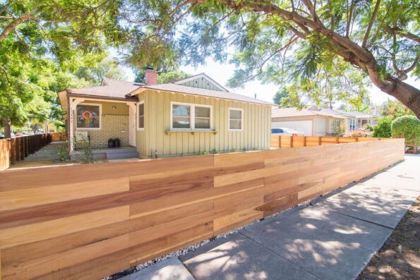 Horizontal redwood fence installed along sidewalk in Los Angeles CA residential landscape by Lush Gardens Inc