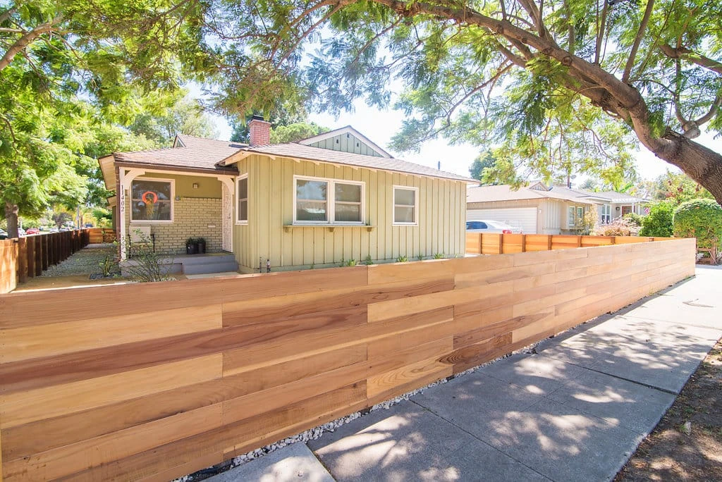 Horizontal redwood fence installed along sidewalk in Los Angeles CA residential landscape by Lush Gardens Inc